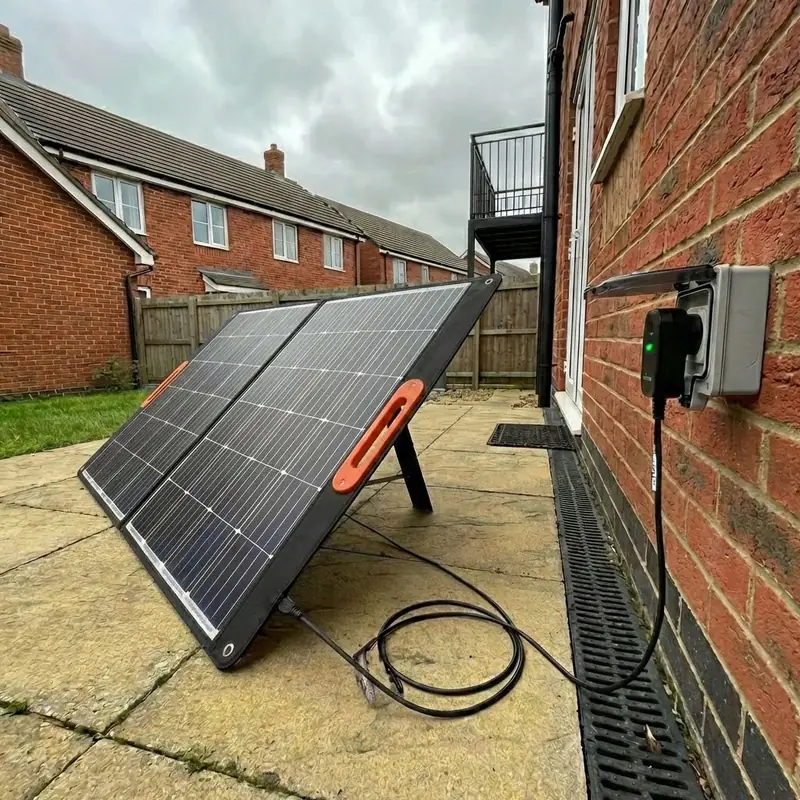 Portable plug-in solar panels set beside a house